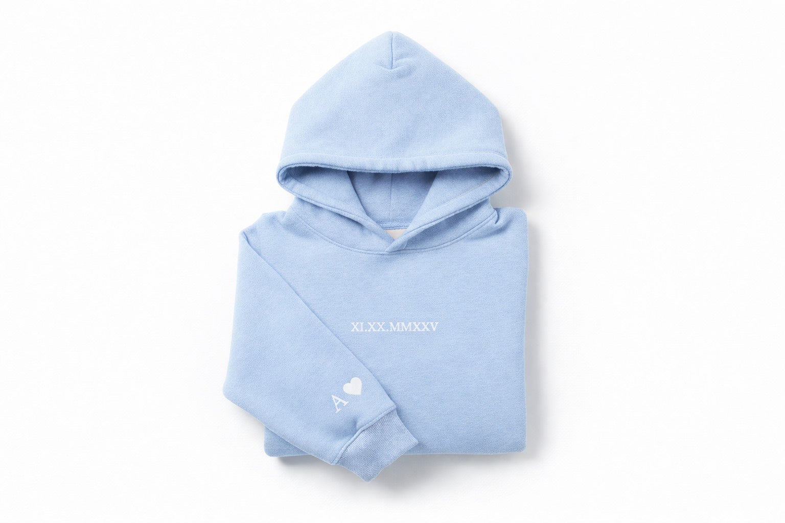 Light blue couples embroidered hoodie with white thread by Sharp Stitch, showcasing personalized roman numerals on the chest and initial with heart embroidery on the sleeve. Custom embroidery and DTF printing on hoodies and crewneck sweatshirts for casual wear and workwear, available with nationwide shipping across the United States.