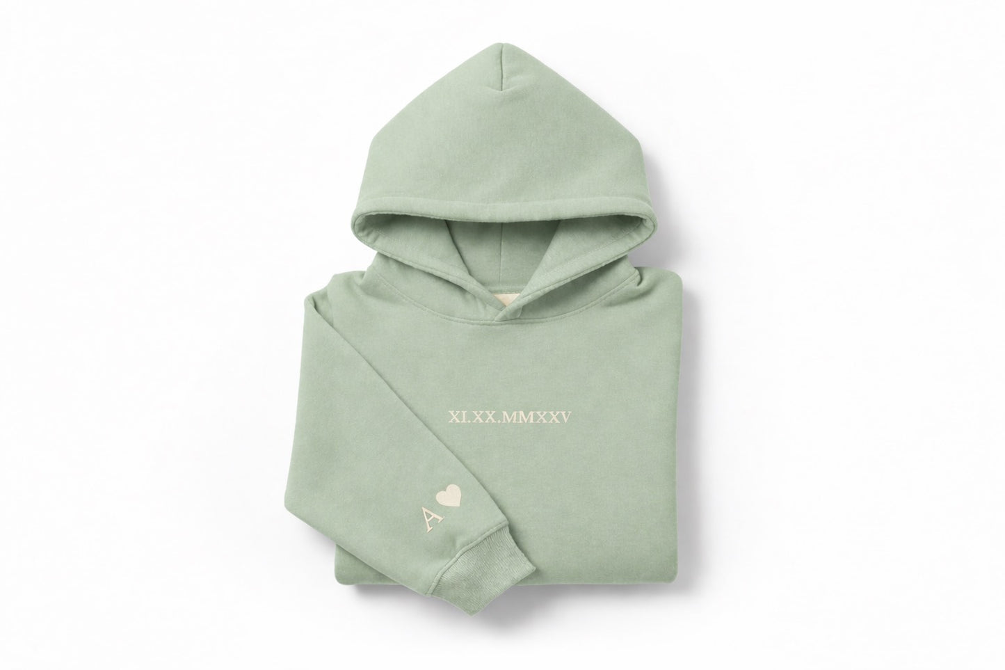 Light green hoodie with tan thread couples embroidery by Sharp Stitch, personalized with roman numerals on the chest and initials with heart embroidery on the sleeve. High quality custom embroidery and DTF printing available on hoodies and crewneck sweatshirts for casual wear and workwear, shipping across all US states.