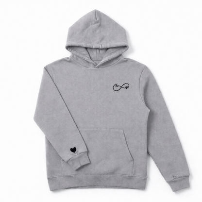 Grey couples hoodie with black embroidered infinity initials and heart sleeve detail, professionally embroidered by Sharp Stitch, serving Illinois and customers across the United States.
