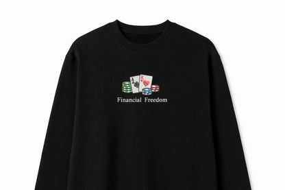 Black crewneck sweatshirt featuring a small center chest embroidery of playing cards, poker chips, and the text Financial Freedom in a minimalist design