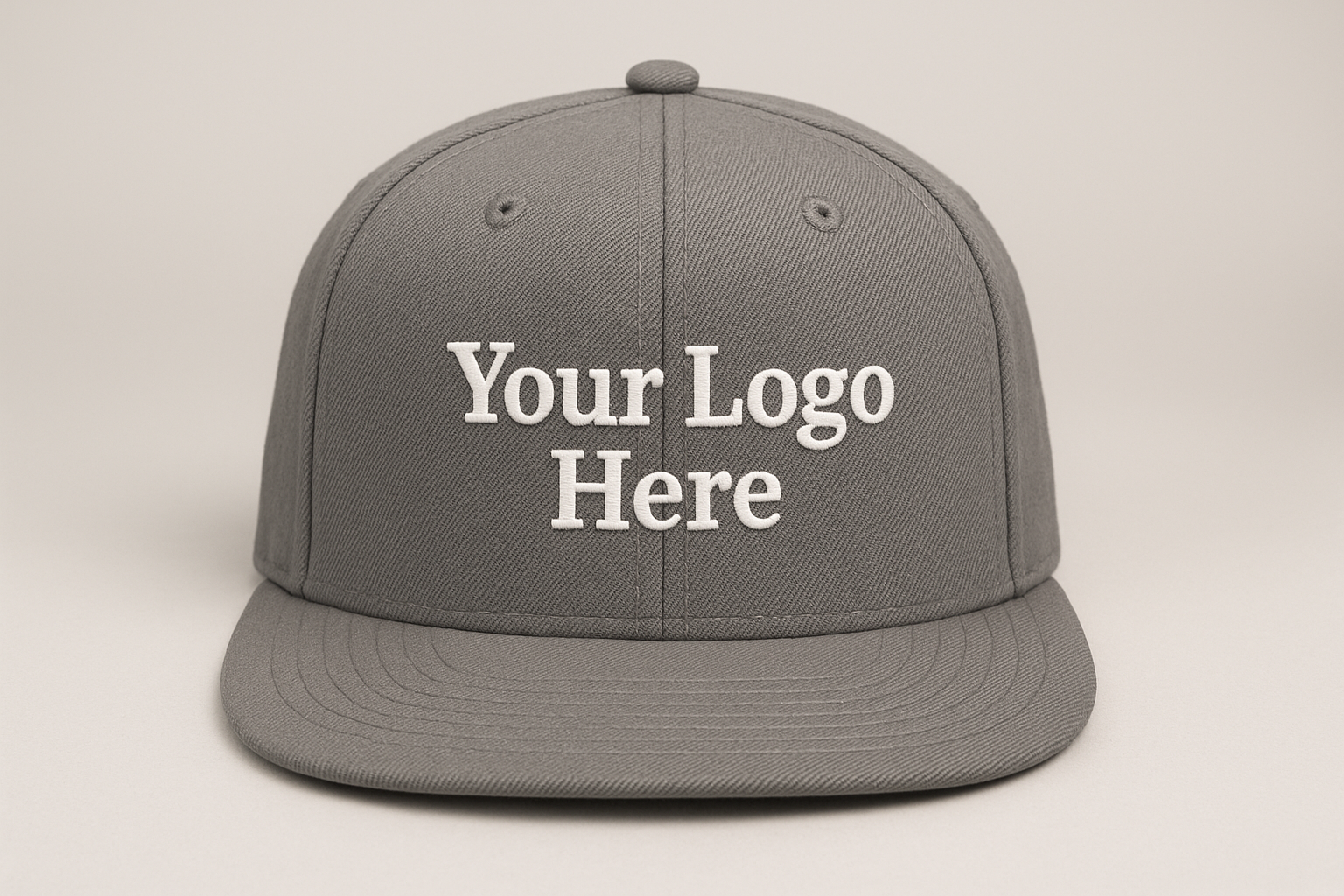 grey snapback flat brim cap, facing forward, with the text: "Your Logo Here" on the cap embroidered