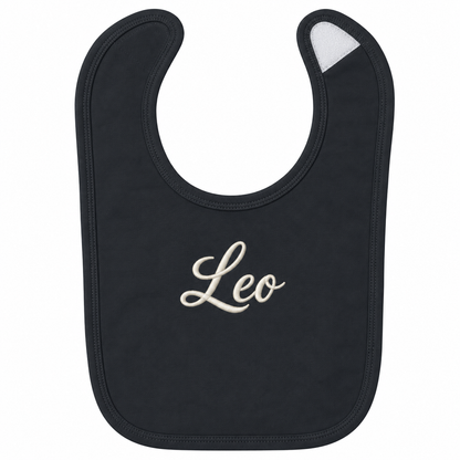 A black baby bib with the name 'Leo' embroidered in white cursive script in the center, shown on a plain white background.

