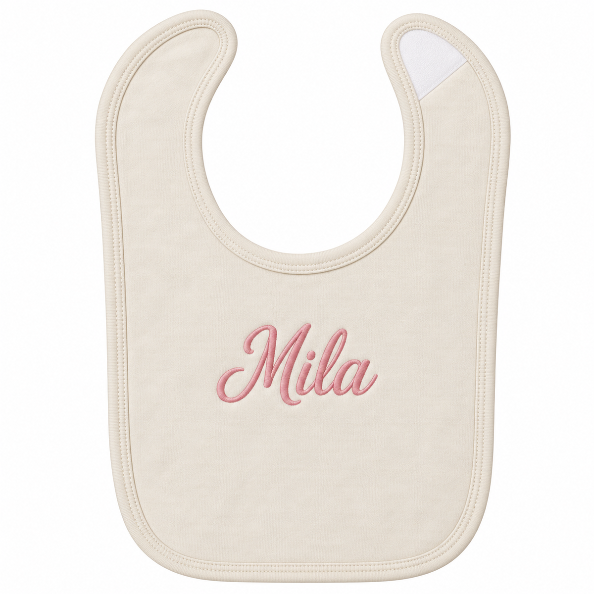 An off-white baby bib with the name 'Mila' embroidered in pink cursive script in the center, shown on a plain white background.

