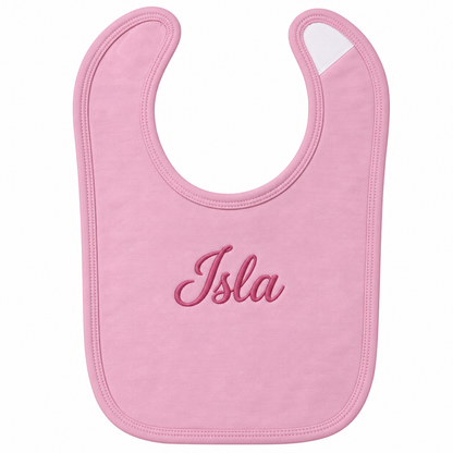 A light pink baby bib with the name 'Isla' embroidered in dark pink script across the center, shown on a plain white background.


