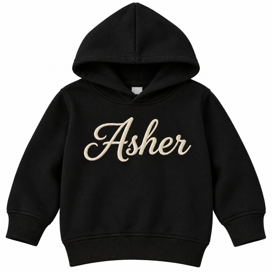 A black kids' pullover hoodie with the name 'Asher' printed across the chest in a beige cursive script, shown against a plain white background.

