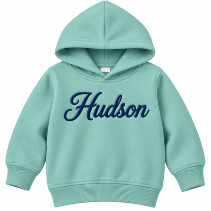A mint green toddler hoodie with 'Hudson' embroidered in navy blue cursive across the chest, shown on a plain white background.

