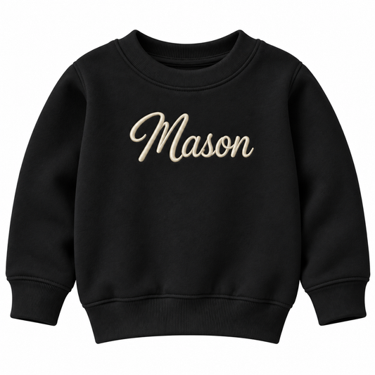 A black crewneck sweatshirt with the name 'Mason' embroidered in a beige cursive font across the chest, shown against a plain white background.

