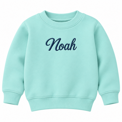 A light mint green crewneck sweatshirt with the name 'Noah' embroidered in dark blue cursive script across the chest, displayed on a clean white background.

